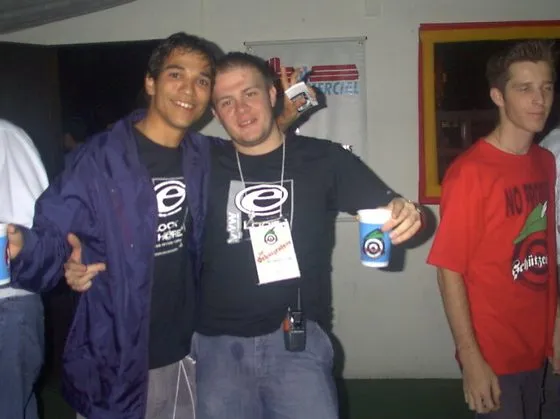Max Pires e Thiago Markiewicz com camisetas da Look Here e credenciais, em cobertura no início dos anos 2000